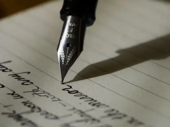 Writing on lined paper with a fountain pen